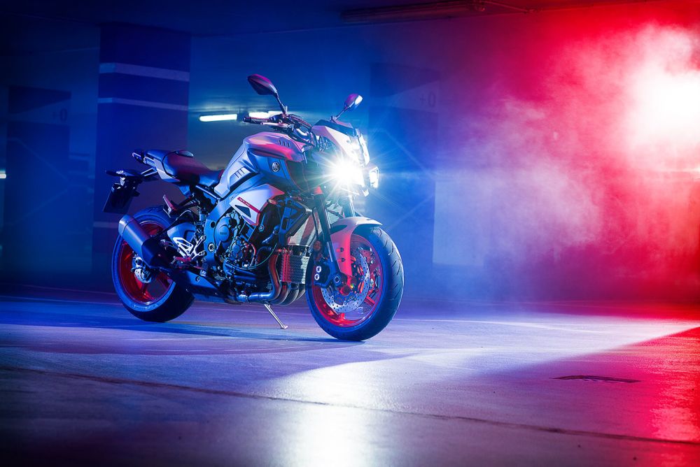 A Yamaha MT10 motorbike in a studio lit up with red and blue.