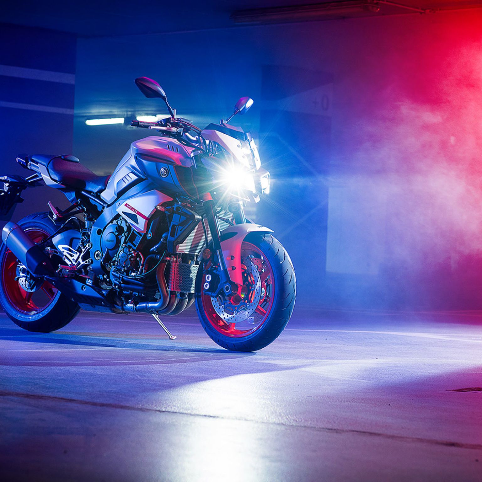A Yamaha MT10 motorbike in a studio lit up with red and blue.
