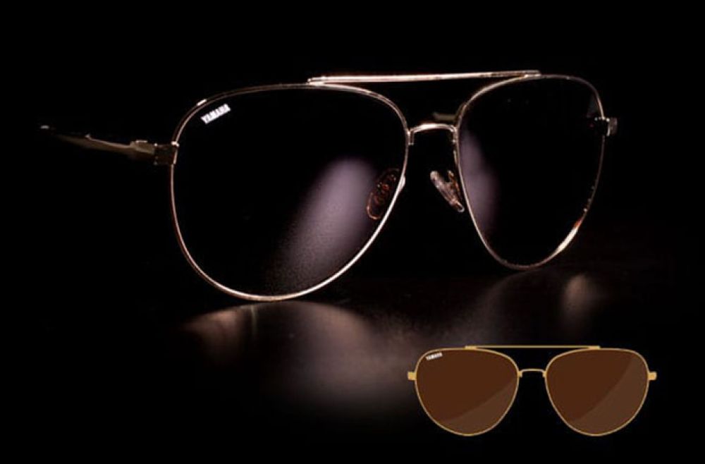 Aviation style Yamaha sunglasses against a dark background.