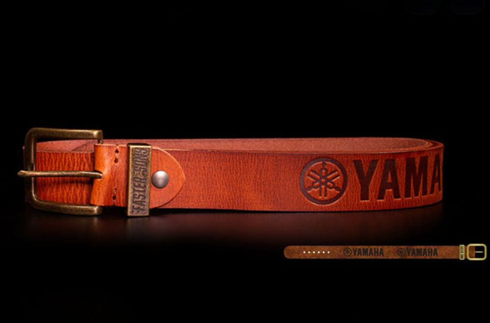 Yamaha tan leather belt against a dark background.