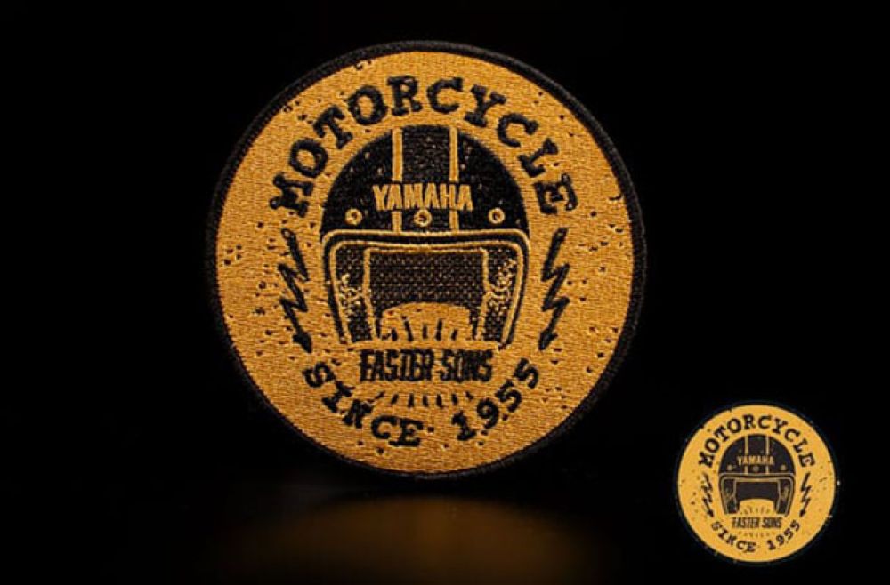 Yamaha yellow motorcycle badge on a dark background, with