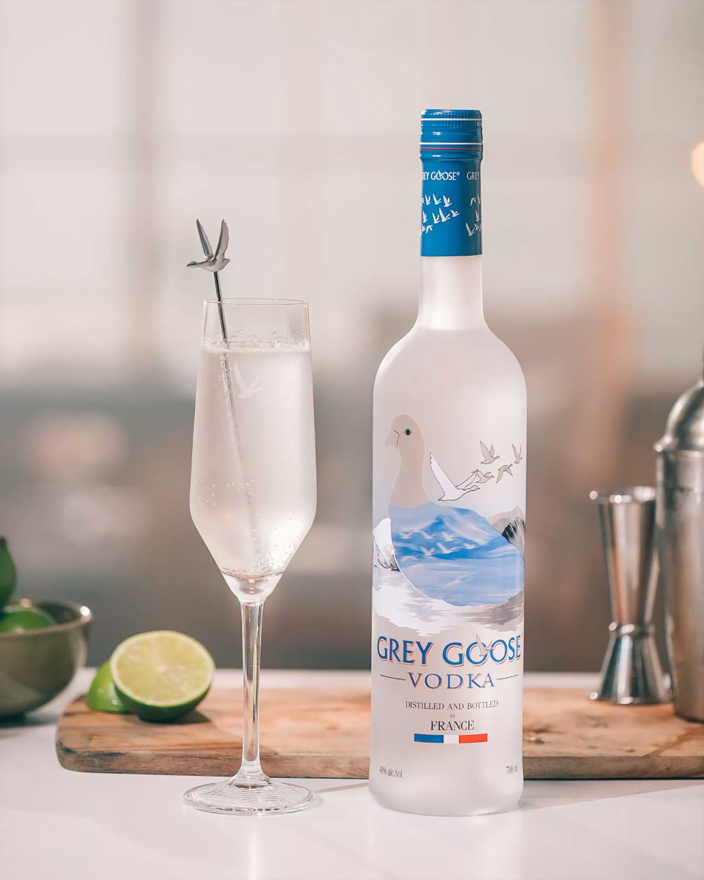 A frosted Grey Goose bottle and flute glass on a kitchen bar.