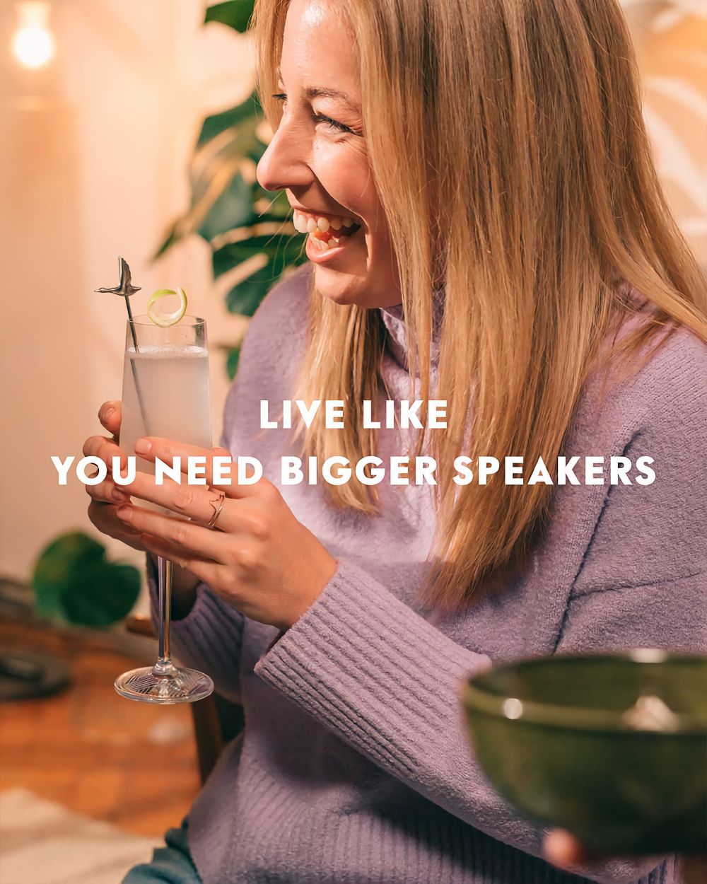 Woman drinking Grey Goose vodka while laughing.