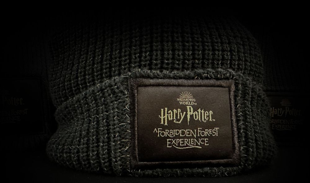 A brown wolly hat with the Forbidden Forest logo stitched on the front.
