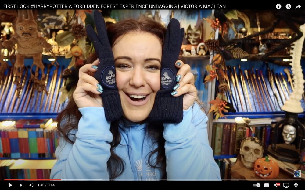 Screenshot of unboxing video with a lady holding up a Forbidden Forest gloves.