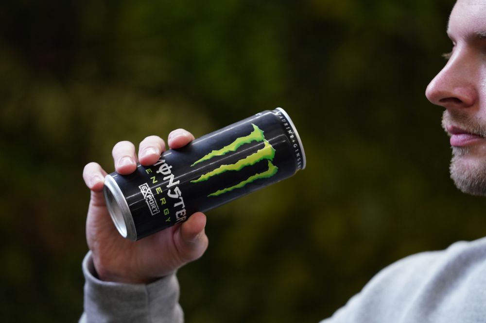 Man drinking a can of Monster Energy.