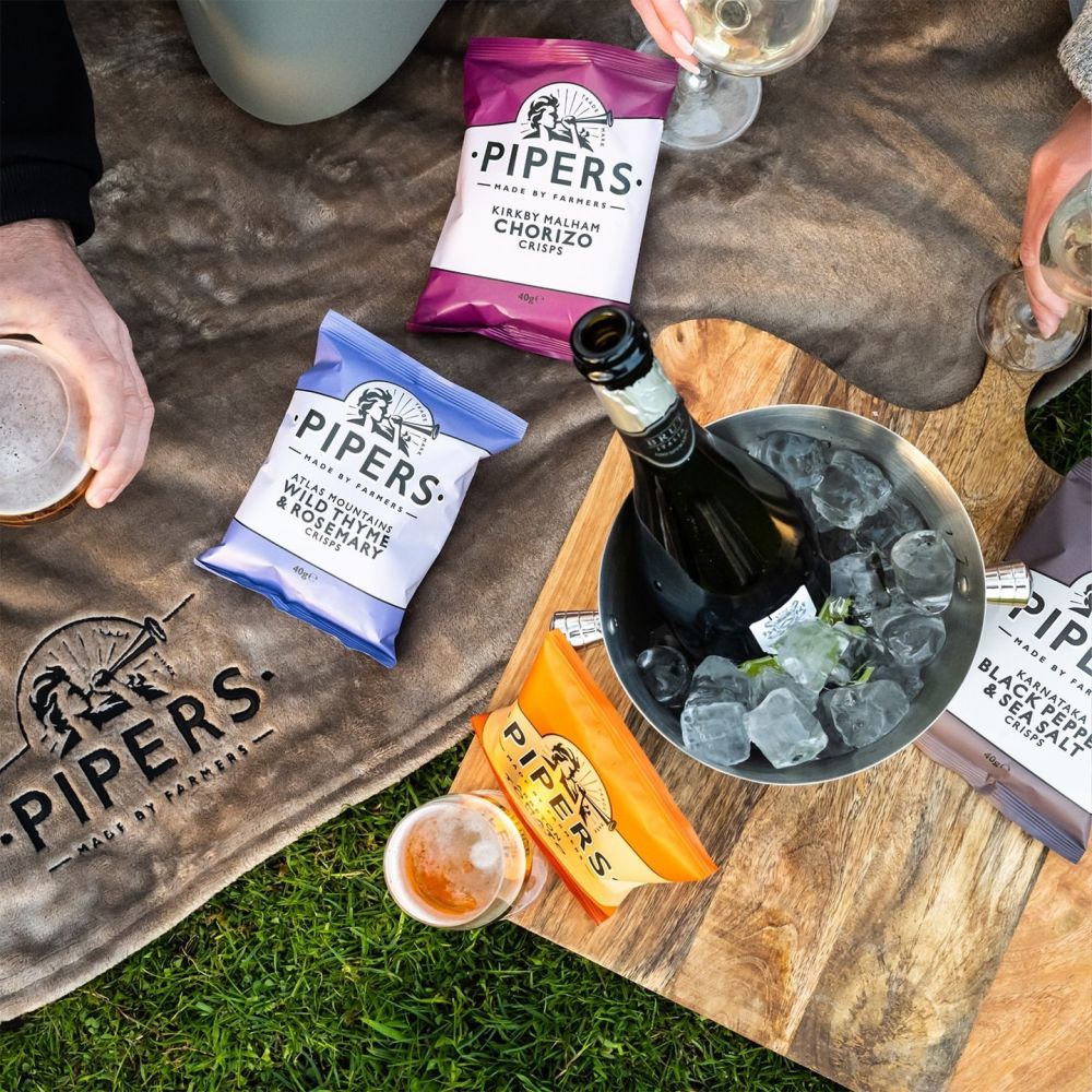 A picnic with Pipers crisps, a bottle of champagne in an ice bucket, beer, and wine.