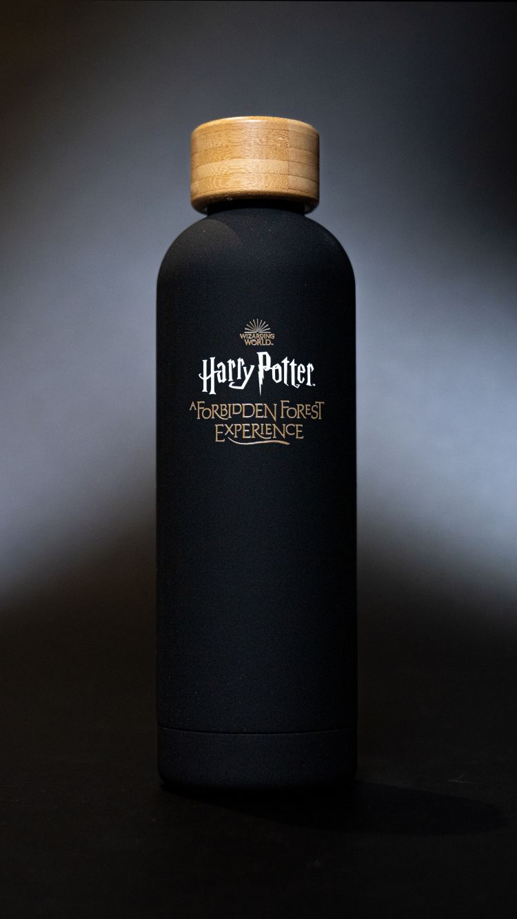 A black water bottle with a wooden top.